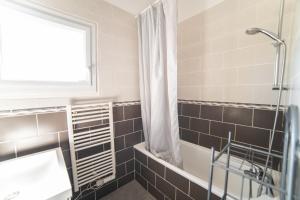 a bathroom with a tub and a sink and a shower at Le Donjon - Agréable T2 centre ville - parking gratuit 2 min - in Mont-de-Marsan +16 photos