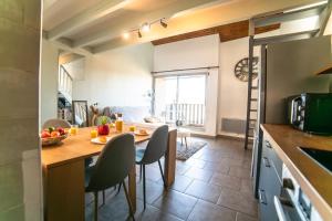 a kitchen and dining room with a table and chairs at Le Donjon - Agréable T2 centre ville - parking gratuit 2 min - in Mont-de-Marsan