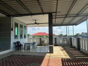 a patio with a table and chairs on a house at De Chempedak Homestay in Kampong Jarak