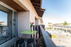 a balcony with a green table and two stools at Le Donjon - Agréable T2 centre ville - parking gratuit 2 min - in Mont-de-Marsan