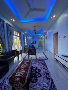 a living room with a couch and a blue ceiling at De Chempedak Homestay in Kampong Jarak
