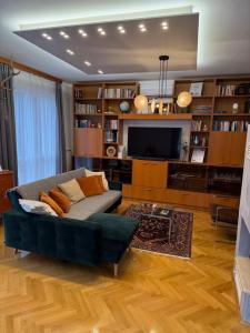 a living room with a couch and a tv at Kozmáry Vendégház in Matrafured