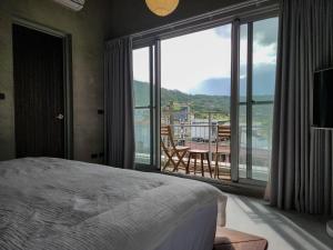 a bedroom with a bed and a view of a balcony at Tomoya in Chenggong