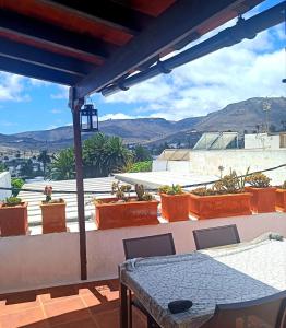 a patio with a table and chairs on a balcony at Casa MaLuMi - Historisches Stadthaus in Haría in Haría