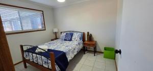 a bedroom with a bed and a window at Spacious - Sunrise over the sea in Urangan