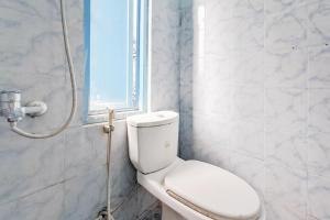 a bathroom with a white toilet and a window at RedDoorz at Arca Hostel Lampung in Lampung +17 photos