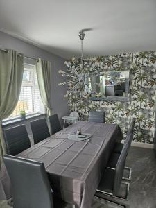 a dining room with a table and chairs and a mirror at ELLIEMAYS in Enniskillen