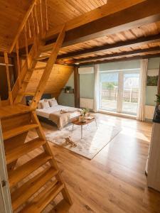 a large room with a bed and a wooden staircase at House by the sea in Klaipėda