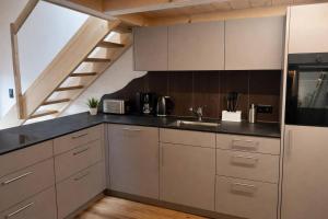 a kitchen with stainless steel cabinets and a staircase at Ap1 20 min to Interlaken in Frutigen