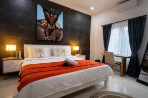 a bedroom with a large bed with a painting on the wall at Central House Ubud - Private Villa in Ubud