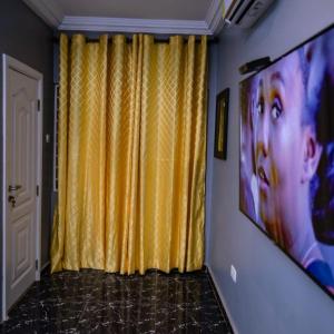 a room with a yellow curtain and a television at Rapid City in Oshiyie