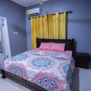 a bedroom with a large bed with pink pillows at Rapid City in Oshiyie