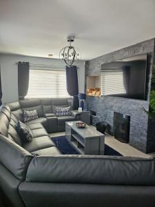 a living room with a couch and a fireplace at ELLIEMAYS in Enniskillen