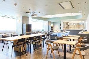 a restaurant with wooden tables and chairs at Heiwadai Hotel 5 in Fukuoka