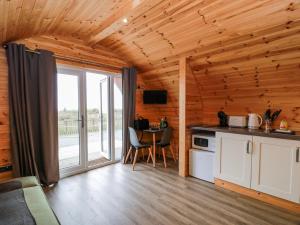 eine Küche in einer Blockhütte mit einem großen Fenster in der Unterkunft Keith in Stranraer