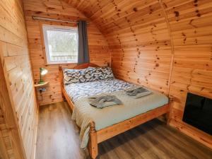 ein Schlafzimmer mit einem Bett in einer Blockhütte in der Unterkunft Keith in Stranraer