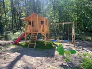 a playground with a tree house and a slide at PROFIL Family House in Pogorzelica