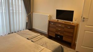 a bedroom with a bed and a television on a dresser at ZBI Apartament in Oradea