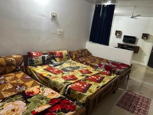 two beds in a room with blankets and pillows at Matha Tourist Home , Cherupuzha in Peringom