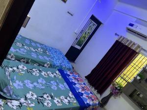 a bedroom with a bed with a blue comforter and a window at Matha Tourist Home , Cherupuzha in Peringom