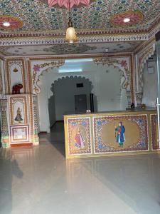 a room with paintings on the walls of a building at Lotus hotel in Nāthdwāra
