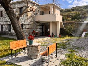 two benches sitting in front of a house at Guest Parents House in Berat