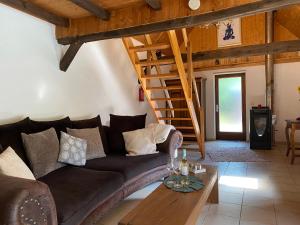 a living room with a couch and a wooden staircase at Zum Schafstall in Hünxe