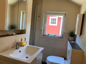 a bathroom with a sink and a toilet and a window at Zum Schafstall in Hünxe +4 photos