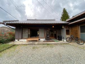 a house with a bench in front of it at Hostel Kumano Kodo in Tanabe