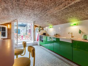 a kitchen with green cabinets and a table and chairs at Wilsons in Utrecht