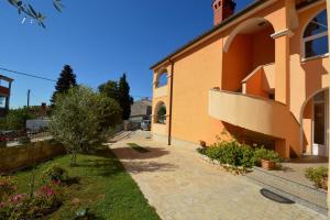 an orange building with a sidewalk next to a yard at Studio in Vinkuran - Istrien 11043 in Vinkuran