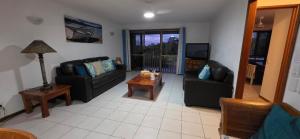 a living room with two couches and a table at Spacious - Sunrise over the sea in Urangan