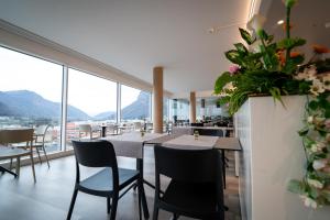 a restaurant with tables and chairs and a large window at Hotel Albergo Milano in Mendrisio