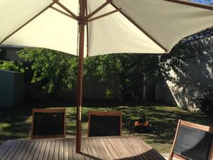a large white umbrella sitting on a wooden deck at L Écrin de Jade Maison de Bourg La MENITRE in La Menitré