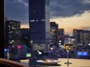a glass of wine and a plate of food on a table at Royal Park Hotel in Tokyo +76 photos