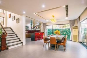 a dining room with a table and chairs and a staircase at Villa FLC Sầm Sơn Thanh Hoá in Sầm Sơn