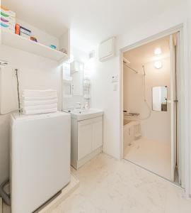 a white bathroom with a sink and a shower at japan house Otsuka in Tokyo