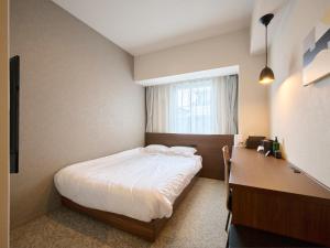 a small bedroom with a bed and a desk at Hotel ARM ObihiroEkimae in Obihiro +50 photos