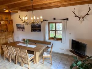 a dining room with a wooden table and a tv at Ferienhaus Wertes in Lohberg