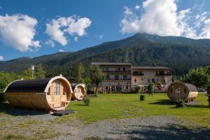 a group of small houses in a field with a mountain at EuroParcs Hermagor - Nassfeld in Hermagor