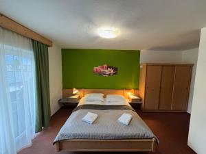 a bedroom with a large bed with a green wall at Apartment House Seerose self check-in in Obertraun +169 photos