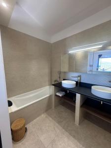 a bathroom with two sinks and a bath tub at Villa MARINE in Ersa +30 photos