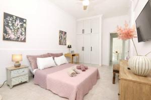 a bedroom with a large bed with a pink blanket at Terranova beach apartment -Rose in Ipsos