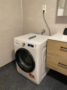 a washing machine in a bathroom with a sink at Heinåli apartment in Isfjorden +17 photos