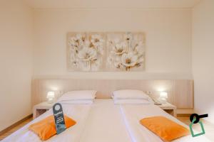 two beds in a room with a picture on the wall at Hotiday Malcesine Garda in Malcesine