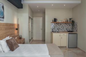 a bedroom with a white bed and a kitchen at Argo Cozy Studios by Estia in Malia +41 photos
