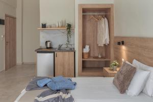 a bedroom with a bed and a kitchen with a sink at Argo Cozy Studios by Estia in Malia