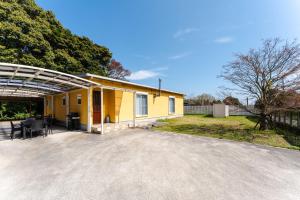 a yellow house with a car driveway at Shimabara 結 Terrace in Shimabara
