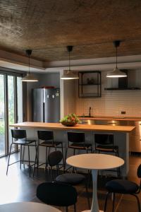 a kitchen with a counter with chairs and a refrigerator at Ozonizia Family Suites Mai Khao Phuket Yacht Haven in Phuket