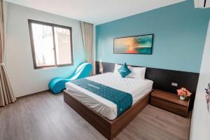a bedroom with a bed and a blue wall at X-Men Hotel Thanh Hoa - Not Near Sam Son Beach in Thanh Hóa